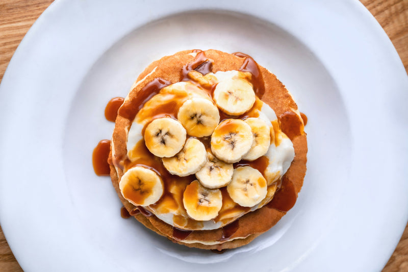 Stack of quick and easy banana oat pancakes with maple syrup