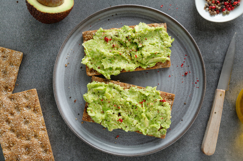 Close-up of creamy mashed avocado spread on toasted sourdough slice